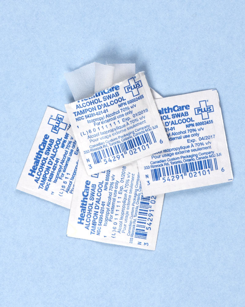 Alchohol swab packets scattered on blue background