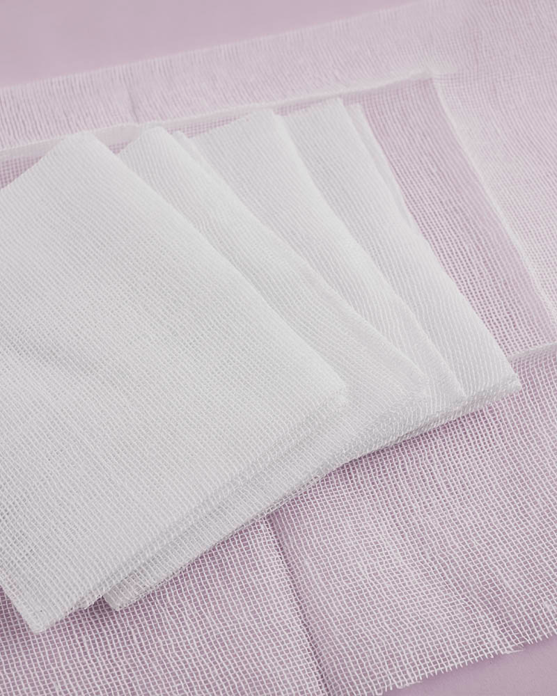 white square cotton gauze pads overlapping each other 